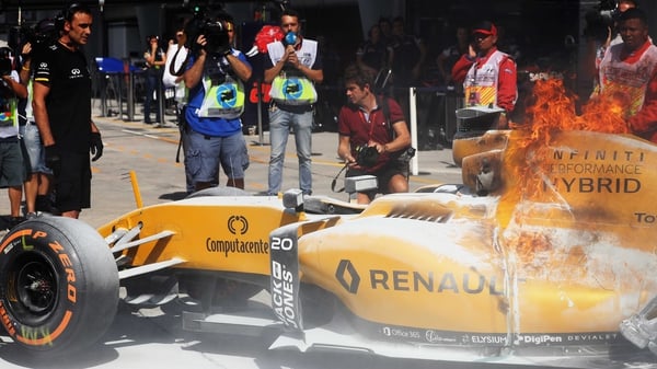 The car of Kevin Magnussen of Denmark and Renault Sport F1 on fire in the pitlane