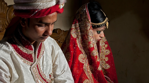 Mohammad Hasamur Rahman, 32, poses for photographs with his new bride, 15-year-old Nasoin Akhter in Bangladesh last year