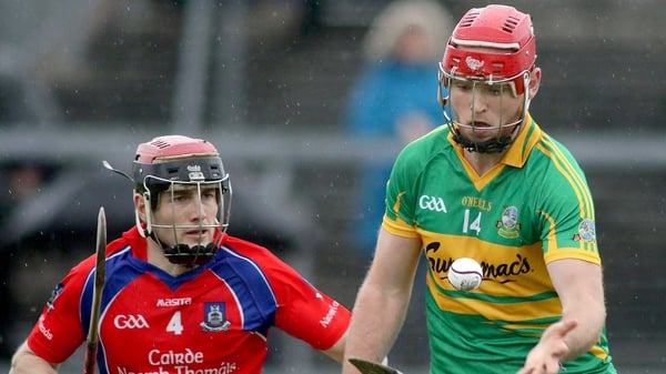 Gort's Michael Mullins hand passes with Cathal Burke close by