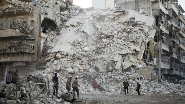 Syrian Civil Defence workers search for victims amid the rubble of a destroyed building in Aleppo