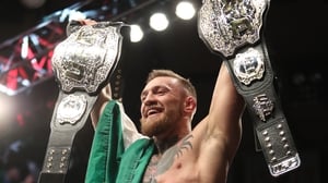Conor McGregor celebrates with his two UFC championship belts