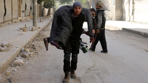 A Syrian civil defence volunteer carries an injured man following a reported air strike on Aleppo's rebel-held neighbourhood of Bab al-Nayrab