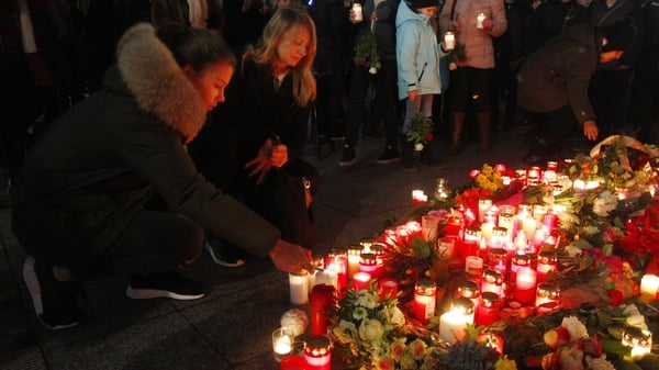 A woman leaves flowers and candles at the area where the attack took place