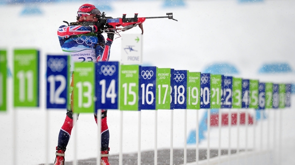 A biathlon competitor shoots at the targets on the range