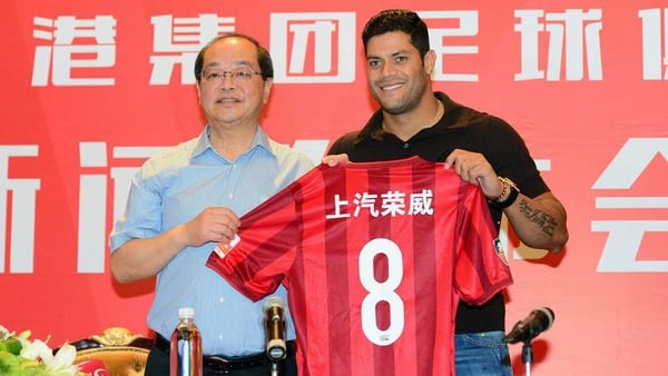 Hulk (R) poses with his new jersey during a press conference after joining Shanghai SIPG