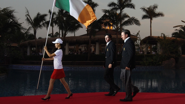 Rory McIlroy walks behind the Irish flag alongside team mate Graeme McDowell before the 2011 World Cup of Golf