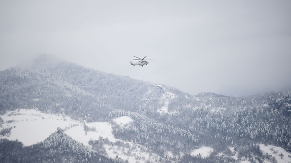 An Italian rescue helicopter flies towards the site of the hotel
