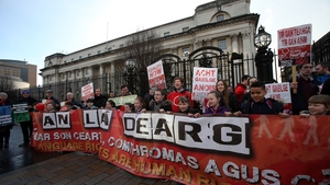 Irish language campaigners from across Northern Ireland hold a banner meaning 'Red with Anger'