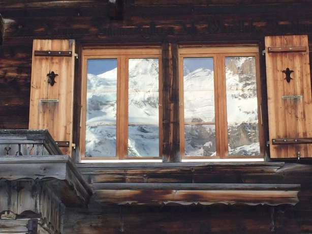 Reflection of the Alps in the window of the Hotel Oeschinense