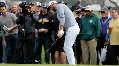 Dustin Johnson chips onto the fourth green during the first round at the Genesis Open