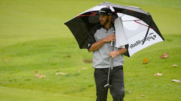 Dustin Johnson prepares to putt on the fourth hole in the rain in California