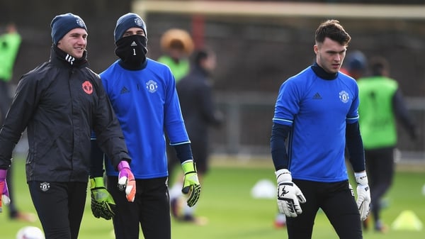 Kieran O'Hara (right) on the Manchester United training ground alongside the masked David De Gea