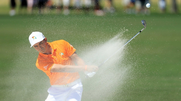 Rickie Fowler plays a shot from a bunker on the sixth