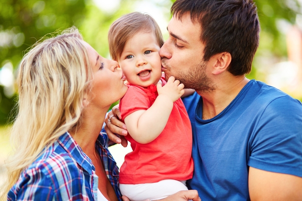 Parents Kissing Child