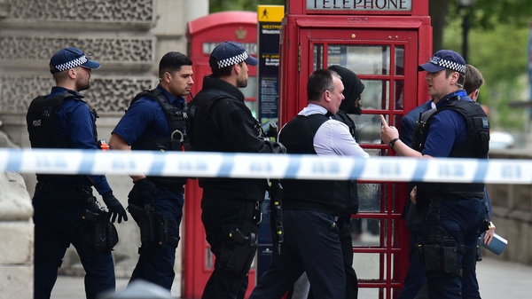 Armed police lead a man away following the incident in Whitehall