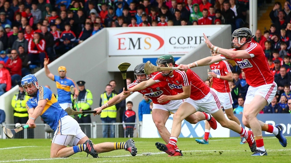 Tipperary's John McGrath lashes over a point despite the efforts of Cork's Colm Spillane, Mark Coleman and Damian Cahalane.