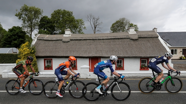 Thw riders pass by a thatched cottage outside of Ballysadare, Co Sligo