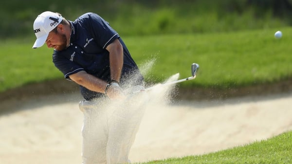 Shane Lowry plays from the bunker on the ninth hole