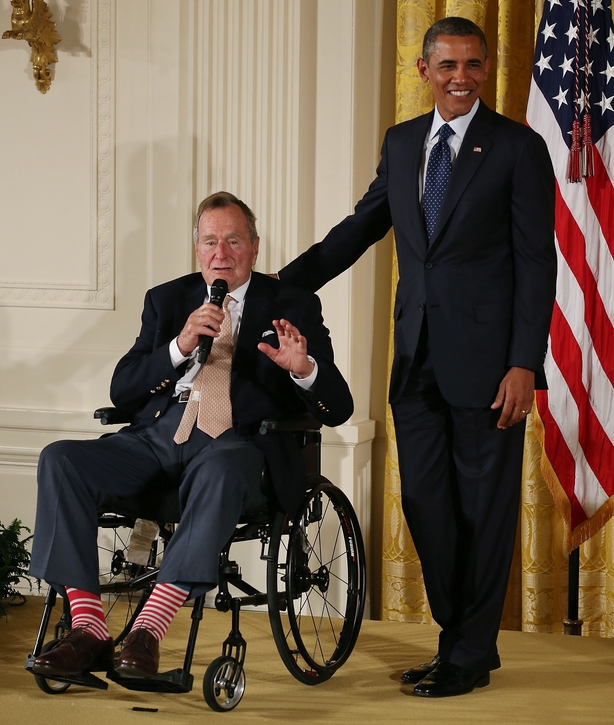 George H. W. Bush speaks while U.S. President Barack Obama stands nearby 