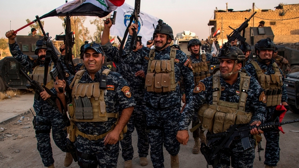 Members of the Iraqi federal police forces celebrate in the Old City of Mosul