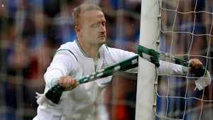 Leigh Griffiths ties a Celtic scarf around a goal post at Windsor Park