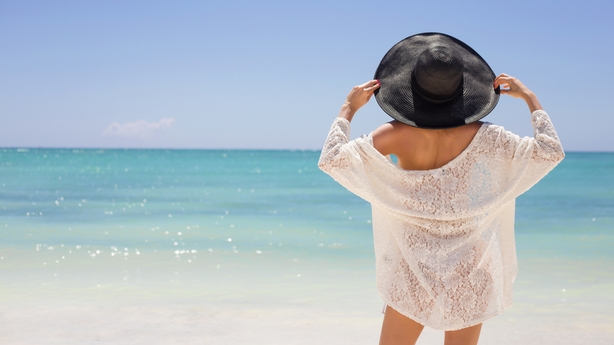 Woman in summer hat on the beach