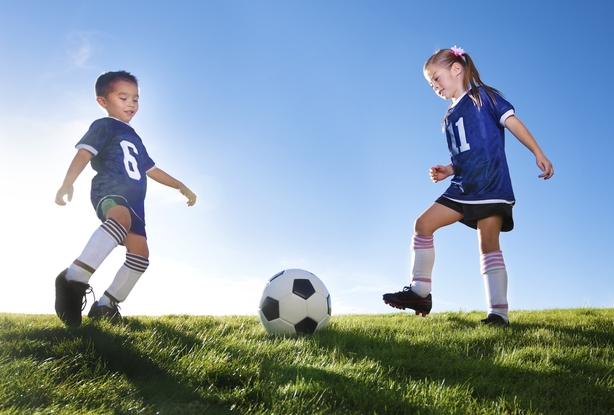 girl and boy playing football
