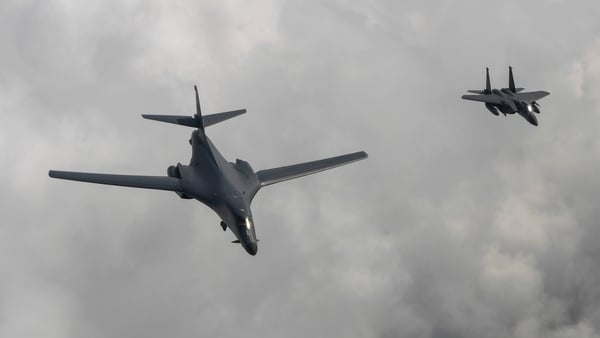 A US B1-B bomber (left) is escorted by a South Korean F-15K fighter as they fly over the Korean peninsula