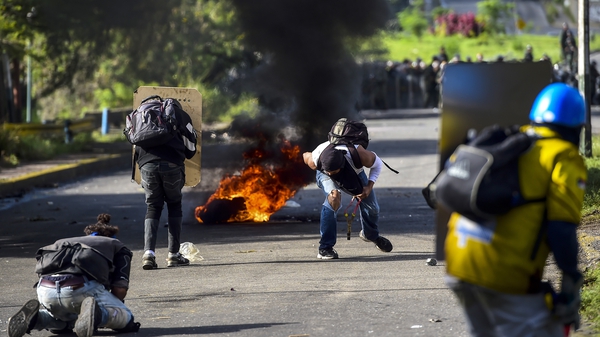 Anti-government activists skirmish with riot police during a protest in Caracas
