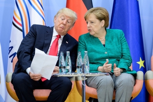Lost in translation: Donald Trump and Angela Merkel compare notes. Photo: EPA/Michael Ukas
