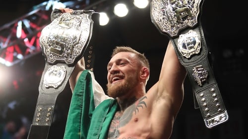 McGregor celebrates becoming a two-weight world champion with victory over Eddie Alvarez in December 2016.