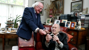 President Michael D Higgins presents playwright Tom Murphy with a gold Torc, in Dublin earlier today