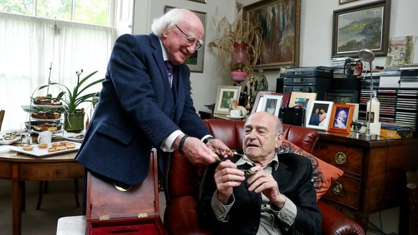President Michael D Higgins presents playwright Tom Murphy with a gold Torc, in Dublin earlier today