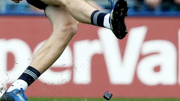The GPS tracker lands at Dean Rock's feet as he strikes the ball