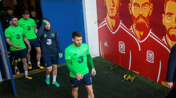 Wes Hoolahan walks by the murals of Wales stars at the Cardiff City Stadium