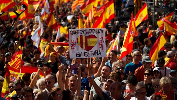 A man holds a card that says 'We want Catalonia in Spain'