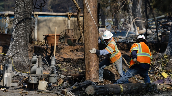 Workers repair power lines following the damage caused by the fire in Santa Rosa, California