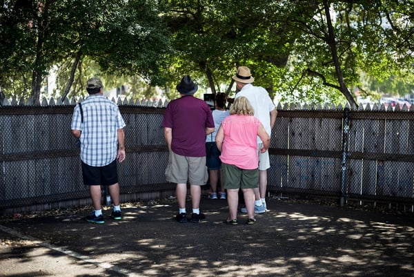 Tourists visit the grassy knoll in Dealey Plaza, which is often cited as a location for an additional shooter