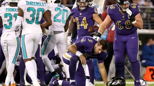 Baltimore Ravens quarterback Joe Flacco (5) is helped up by Matt Skura (68) after taking a hard hit and leaving the game against the Miami Dolphins