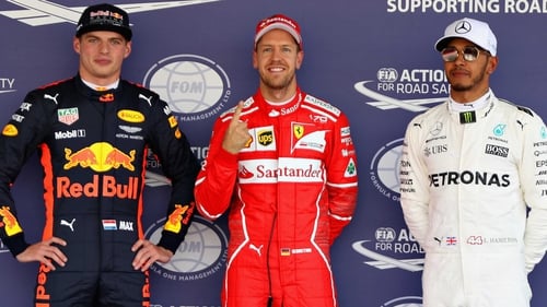 Sebastian Vettel, flanked by Max Verstappen (L) and Lewis Hamilton (R), celebrates his pole