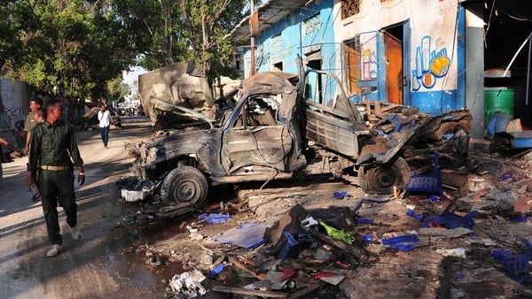 Residents walk at the scene in Mogadishu