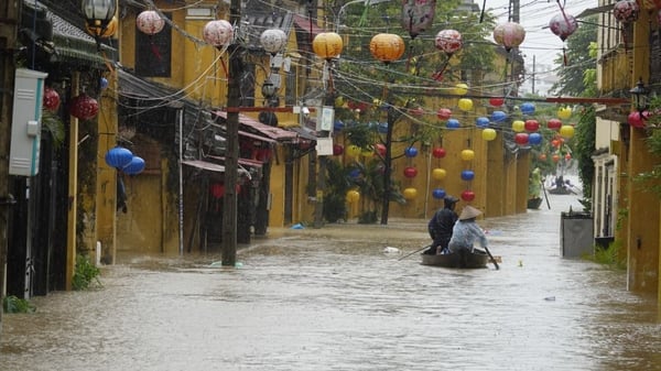 Local residents navigate a boat in the flooded tourist town of Hoi An