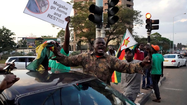 People celebrate in Harare after Robert Mugabe announced his resignation as Zimbabwe's President