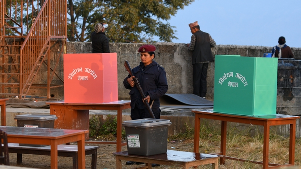 A Nepali police woman stands guard at a polling station during the general election
