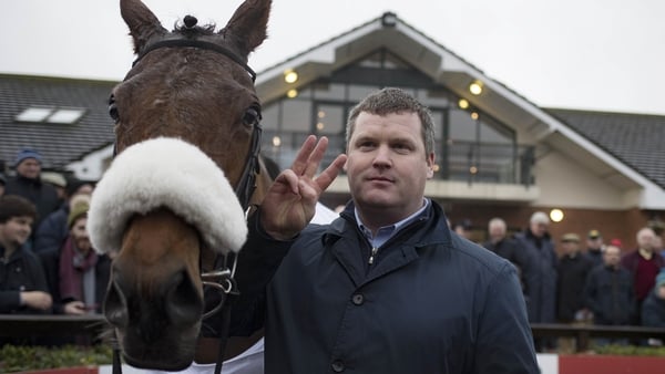 Trainer Gordon Elliott poses with Death Duty to celebrate winning the three Grade One races on the card