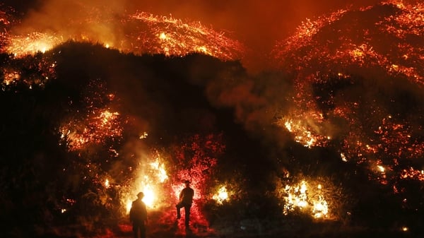 Firefighters monitor a section of the Thomas Fire north of Ventura, California