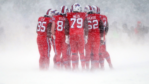 The Buffalo Bills offense huddles together in freezing conditions