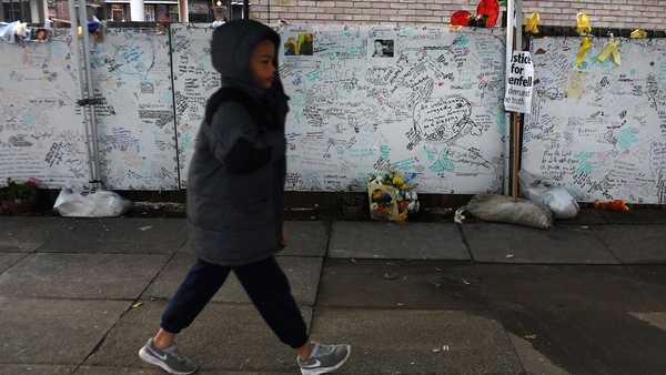A young boy walks past tributes to Grenfell Tower residents in west London
