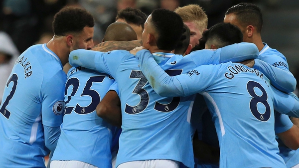 Manchester City players mob Raheem Sterling after his decisive goal