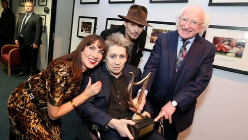 Shane MacGowan is presented with his NCH Lifetime Achievement Award by President Michael D. Higgins, in the company of his partner Victoria Mary Clarke and Johnny Depp.